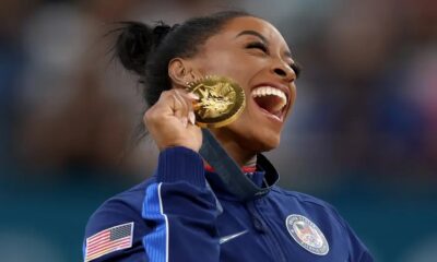 Simone Biles of Team United States celebrates on the podium during the medal ceremony for the Artistic Gymnastics Women