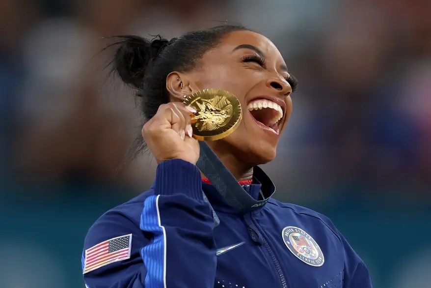 Simone Biles of Team United States celebrates on the podium during the medal ceremony for the Artistic Gymnastics Women